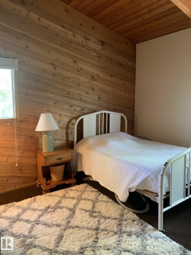 Wood-paneled accent wall with a matching wood-paneled ceiling - #446 67432 Mcgrane Rd, Rural Lac La Biche County, AB 