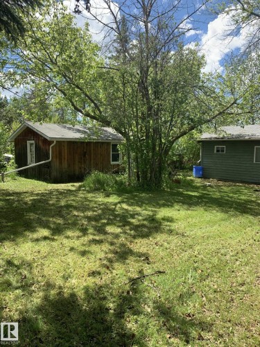 Expansive green lawn with dappled sunlight - #446 67432 Mcgrane Rd, Rural Lac La Biche County, AB 
