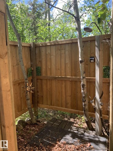Outdoor shower enclosure featuring natural wood fencing and mature trees - #446 67432 Mcgrane Rd, Rural Lac La Biche County, AB 