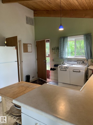 Kitchen featuring wood-finish ceiling, exposed beam, recessed lighting, and a suspended pendant light - #446 67432 Mcgrane Rd, Rural Lac La Biche County, AB 