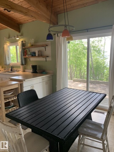 Open-concept kitchen and dining area featuring a vaulted wood-beam ceiling - #446 67432 Mcgrane Rd, Rural Lac La Biche County, AB 
