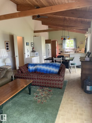 Vaulted wood-paneled ceiling with exposed beams, illuminated by track lighting and a ceiling fan - #446 67432 Mcgrane Rd, Rural Lac La Biche County, AB 