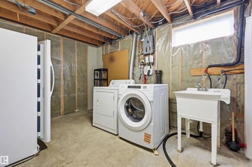 Laundry area featuring a utility sink, washer, and dryer - 10712 52 Avenue, Edmonton, AB 