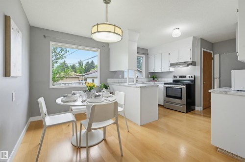 Open-concept kitchen and dining area featuring light wood-finish flooring - 10712 52 Avenue, Edmonton, AB 