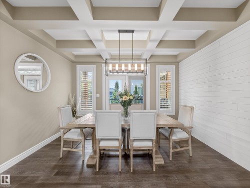 Spacious room featuring a coffered ceiling, wood-finish flooring, and a white shiplap accent wall - 5608 Soleil Boulevard, Beaumont, AB 