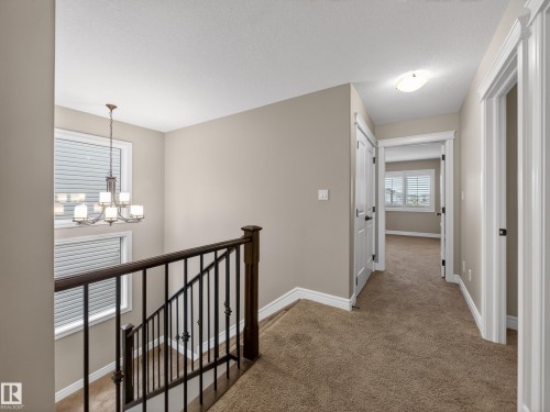 Upper-level hallway featuring plush carpet flooring and neutral wall tones - 5608 Soleil Boulevard, Beaumont, AB 