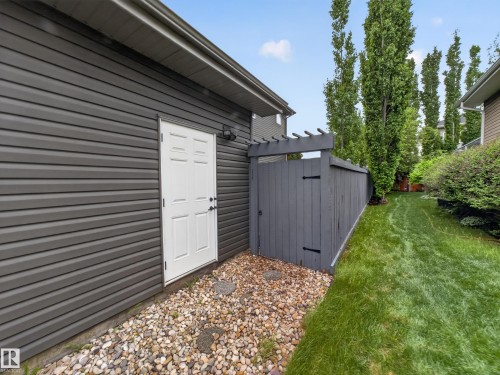 Exterior siding in a dark gray horizontal paneling, featuring a white paneled door with black hardware - 5608 Soleil Boulevard, Beaumont, AB 