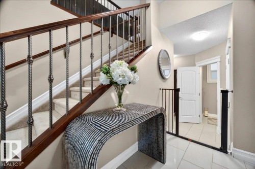 Staircase featuring decorative wrought iron balusters and wood handrails - 1326 Cunningham Drive, Edmonton, AB 