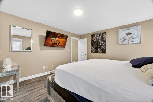 Bedroom featuring wood-finish flooring, neutral wall paint, and white trim - 1326 Cunningham Drive, Edmonton, AB 