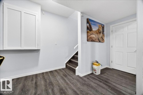 Entry area featuring wood-finish flooring, light gray walls, and white baseboards - 1326 Cunningham Drive, Edmonton, AB 