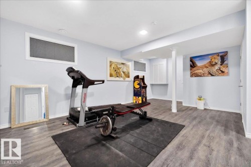 Spacious room featuring wood-finish flooring, recessed lighting, and light-toned walls - 1326 Cunningham Drive, Edmonton, AB 