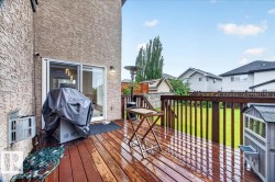 Expansive wood deck with dark stain, featuring a sliding glass door entry to the interior - 