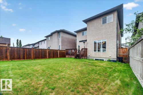 Expansive backyard with a wooden fence and a two-story residence featuring stucco siding - 1326 Cunningham Drive, Edmonton, AB 