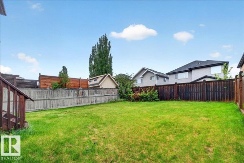 Expansive grassy yard area featuring a multi-tone wood fence perimeter - 1326 Cunningham Drive, Edmonton, AB 