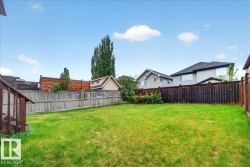 Expansive grassy yard area featuring a multi-tone wood fence perimeter - 