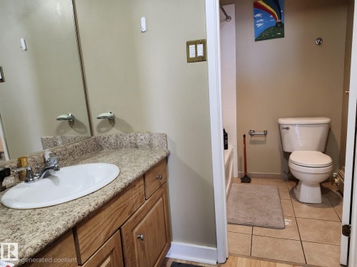 Bathroom vanity with granite-finish countertop, undermount sink, and wood cabinetry - 1600 10149 Saskatchewan Drive, Edmonton, AB 