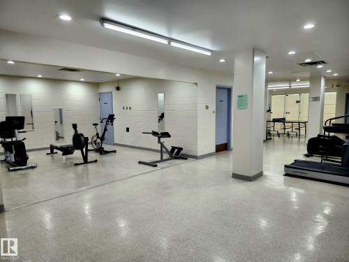 Fitness center featuring recessed lighting, fluorescent overhead lighting, and a durable speckled floor - 1600 10149 Saskatchewan Drive, Edmonton, AB 