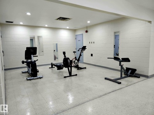 Interior fitness space featuring light-colored block walls and a tiled floor - 1600 10149 Saskatchewan Drive, Edmonton, AB 