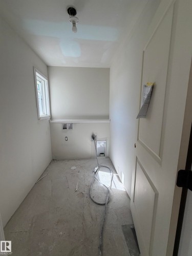 Utility room with a single window, white walls, and a panel-style door - 2206 Crossbill Link, Edmonton, AB 