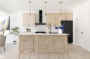 Kitchen island featuring a dark countertop with an undermount sink and matte black faucet - 2206 Crossbill Link, Edmonton, AB 