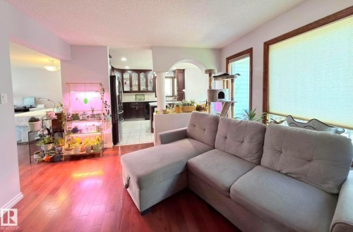 Hardwood-finish flooring throughout the main living area looking towards the kitchen. - 825 112B St, Edmonton, AB 