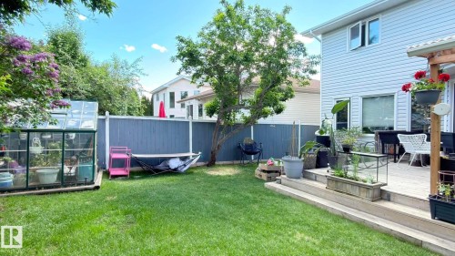 Expansive backyard featuring a manicured lawn, a privacy fence, and a multi-level wooden deck. - 825 112B St, Edmonton, AB 