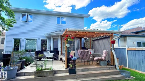 Multi-level deck with a wood pergola, and light-colored siding. - 825 112B St, Edmonton, AB 