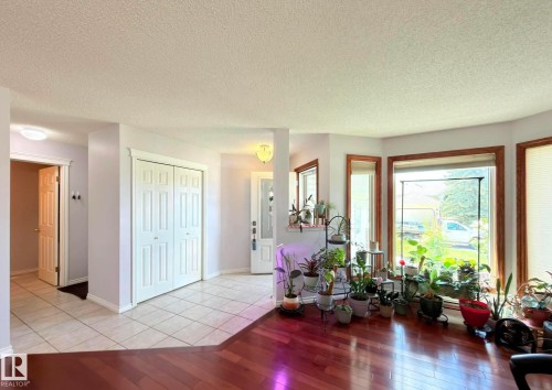 Entryway featuring a ceramic tile floor, double bi-fold coat closet doors, and a lot of natural lights. - 825 112B St, Edmonton, AB 