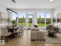 Open-concept living area with wood-finish flooring, abundant natural light, and a rear yard with a perimeter fence - 8108 230 Street, Edmonton, AB 