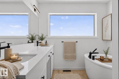 Contemporary bathroom featuring a freestanding soaking tub with matte black fixtures - 8108 230 Street, Edmonton, AB 