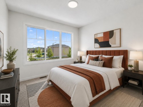 Bright bedroom featuring a large multi-pane window, flush-mount ceiling light, light-colored walls, and carpet flooring - 8108 230 Street, Edmonton, AB 