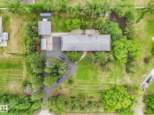 Expansive property featuring a main residence with a gray shingle roof, a detached garage with a matching shingle roof, and a paved driveway - 11921 231 Street, Edmonton, AB 