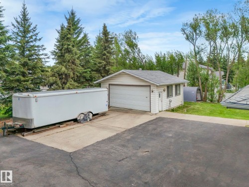 Detached garage with a single overhead door, an exterior side door, and two windows - 11921 231 Street, Edmonton, AB 