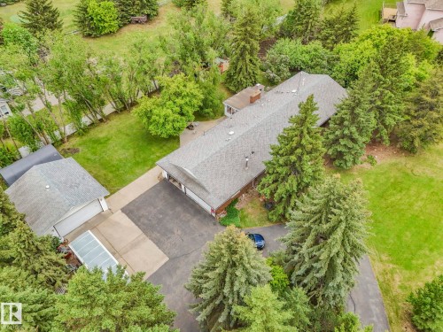 Expansive property featuring a central residence with a gabled roof, detached garage, and multiple paved driveways - 11921 231 Street, Edmonton, AB 