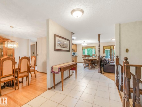Foyer featuring white tile flooring, a wood staircase, and an open concept layout - 11921 231 Street, Edmonton, AB 