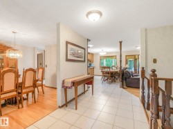 Foyer featuring white tile flooring, a wood staircase, and an open concept layout - 