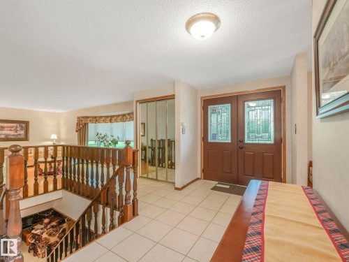 Entry foyer featuring ceramic tile flooring and double entry doors with decorative glass inserts - 11921 231 Street, Edmonton, AB 