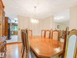 Dining area featuring wood-finish flooring, a contemporary chandelier, and light-toned walls - 