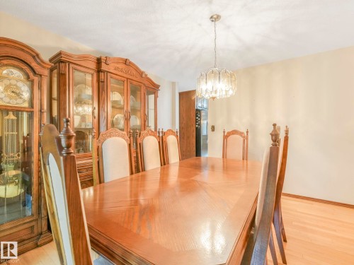 Spacious dining area featuring blonde wood-finish flooring and a central chandelier - 11921 231 Street, Edmonton, AB 