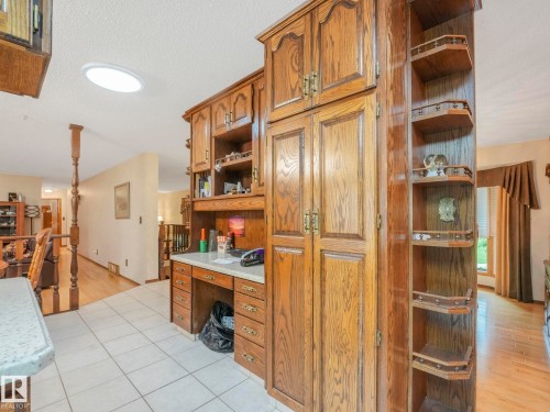 Built-in desk area with wood cabinetry, white countertop, and integrated corner shelving - 11921 231 Street, Edmonton, AB 