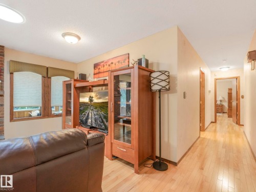 Living area featuring light wood-finish flooring, neutral wall tones, and recessed lighting - 11921 231 Street, Edmonton, AB 