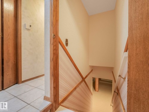Stairwell featuring wood-finish railings and light-toned wall finishes - 11921 231 Street, Edmonton, AB 