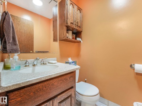 Vanity with a light-toned countertop, integrated sink, and chrome faucet - 11921 231 Street, Edmonton, AB 