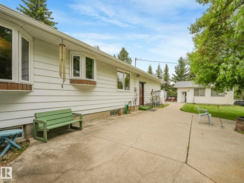 White horizontal siding exterior with multiple bay windows and a concrete patio - 11921 231 Street, Edmonton, AB 