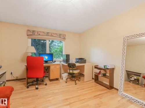 Room featuring wood-finish flooring, a window with exterior views, and neutral wall tones - 11921 231 Street, Edmonton, AB 