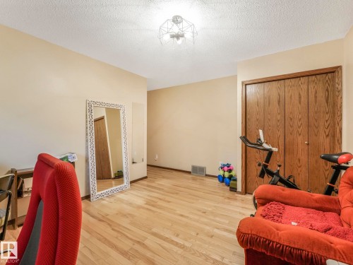 Room featuring wood-finish flooring, neutral wall tones, and a textured ceiling - 11921 231 Street, Edmonton, AB 