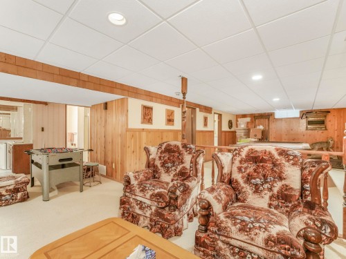 Finished lower level featuring a drop ceiling with recessed lighting, wood-paneled walls, and plush carpeting - 11921 231 Street, Edmonton, AB 