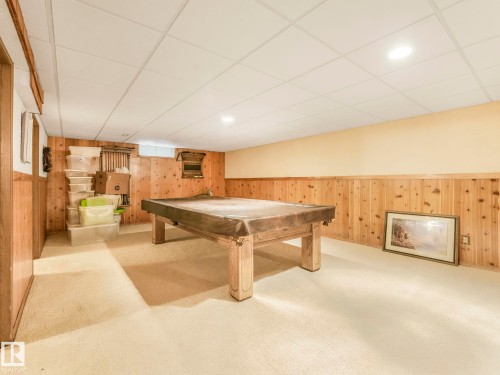Finished room featuring neutral carpet flooring and wood paneling on lower walls - 11921 231 Street, Edmonton, AB 