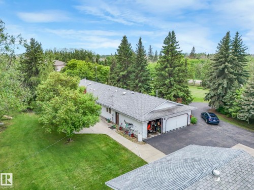 Ranch-style exterior with white siding, a multi-gabled roof, and attached two-car garage - 11921 231 Street, Edmonton, AB 