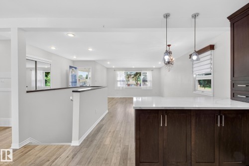 Kitchen island with white countertop and dark wood-finish cabinetry - 3 Galaxy Way, Sherwood Park, AB 